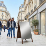 Stop trottoir moderne vierge sur un trottoir animé d'une rue commerçante française. Des passants et boutiques sont visibles.